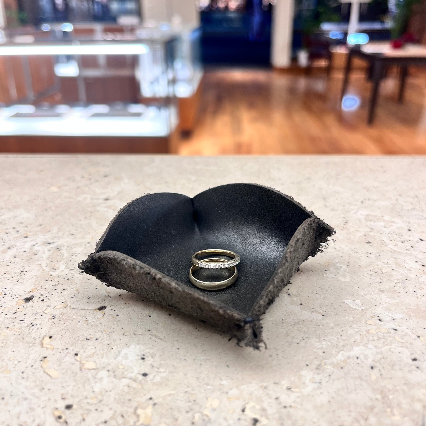 A black leather ring tray, perfect for storing jewelry and adding a touch of elegance to your space.