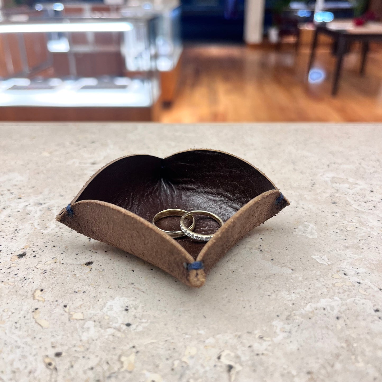A classic brown leather ring tray, ideal for organizing rings, earrings, and other small accessories.