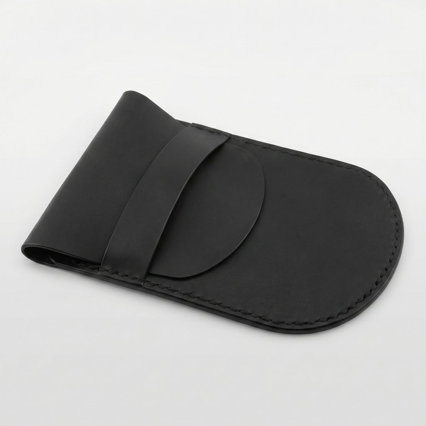 Minimalist black full-grain leather protective case for Apple Magic Mouse featuring hand-stitched edges and a secure leather strap closure on a white background.