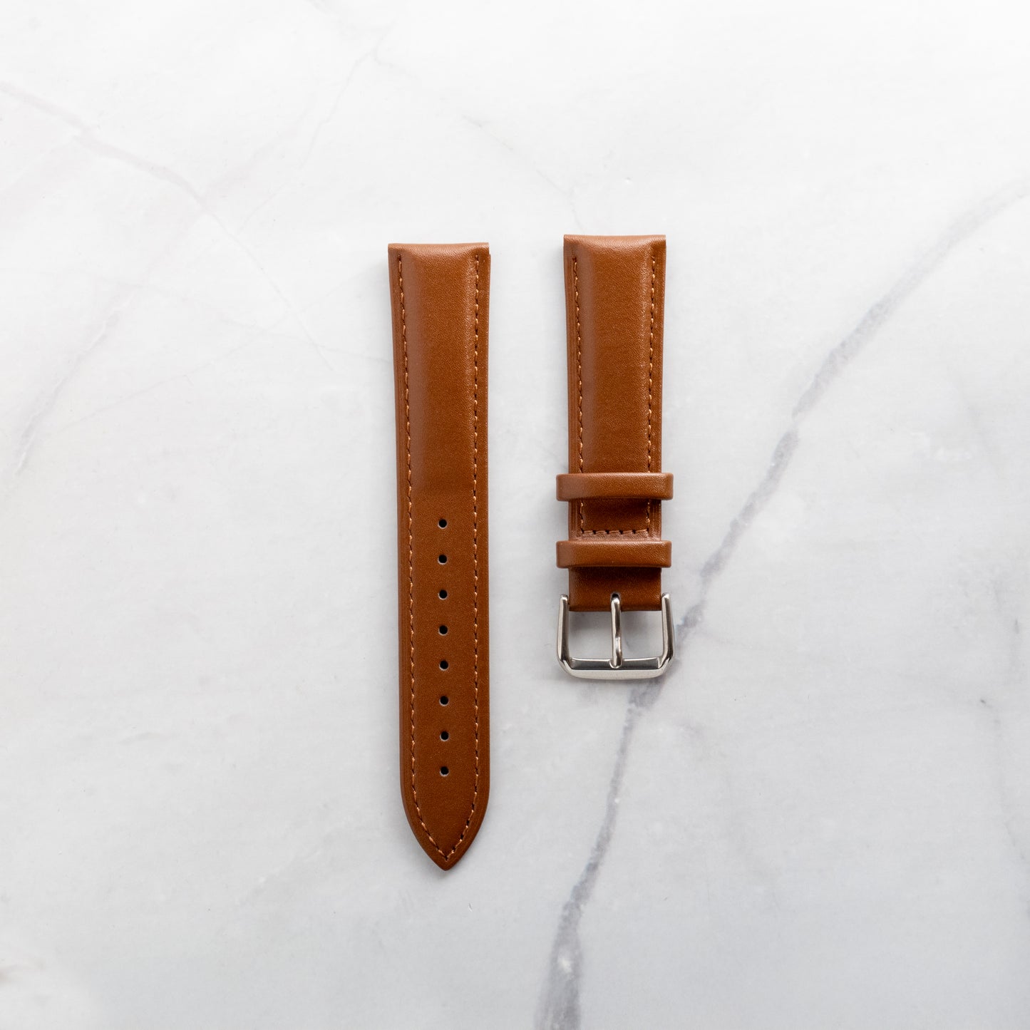 Warm tan brown genuine leather watch strap with artisan stitching and a soft-touch finish, available with a standard silver buckle or an upgraded butterfly clasp.