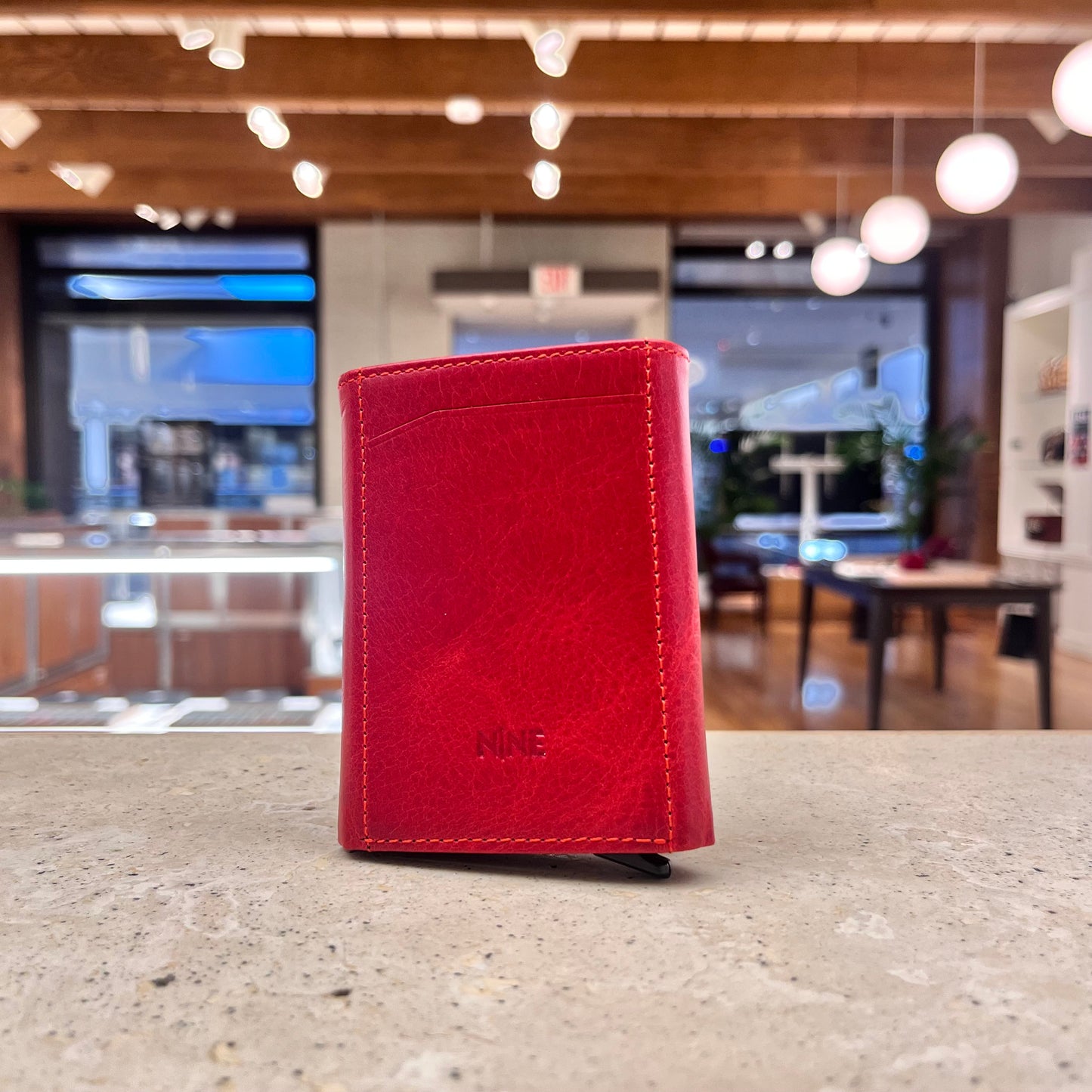 A vibrant red NINE Leather & Watch Mechanical Wallet, emphasizing its bold color and modern design.