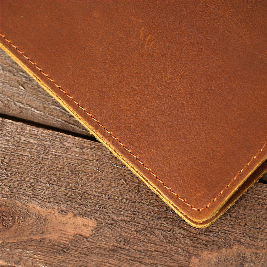 Close-up of a corner on a tan brown handmade oil waxed leather Long Snap Wallet, showcasing the detailed stitching, leather texture, and rustic wooden background.