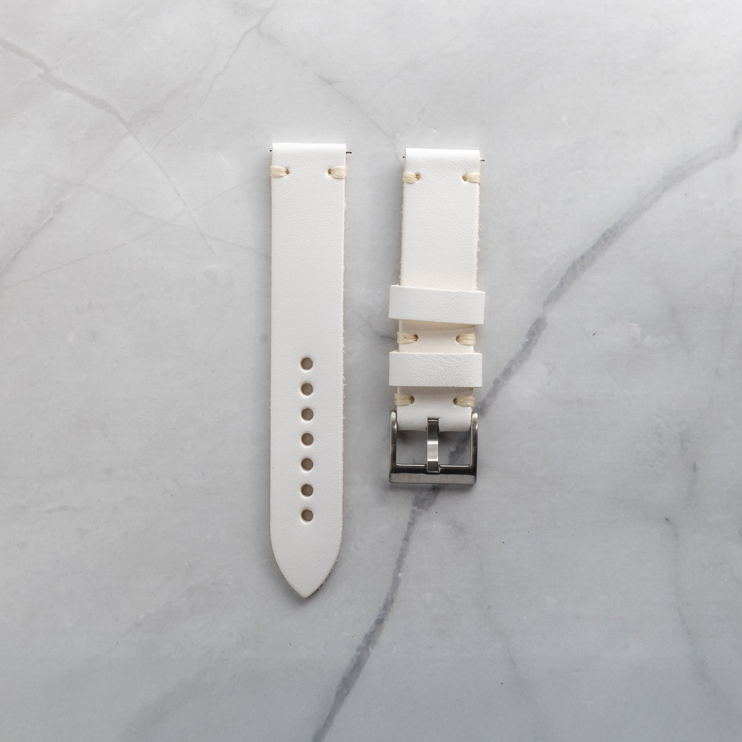 Meticulously fashioned white full-grain leather watch band with beige artisan hand-stitching, highlighting the supple texture and refined aesthetic of the material.