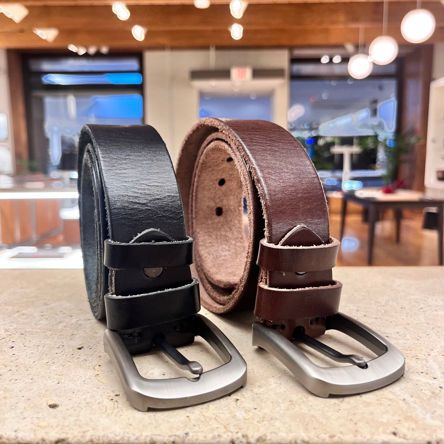 A pair of handcrafted leather belts in black and brown, highlighting the quality and versatility of our collection.