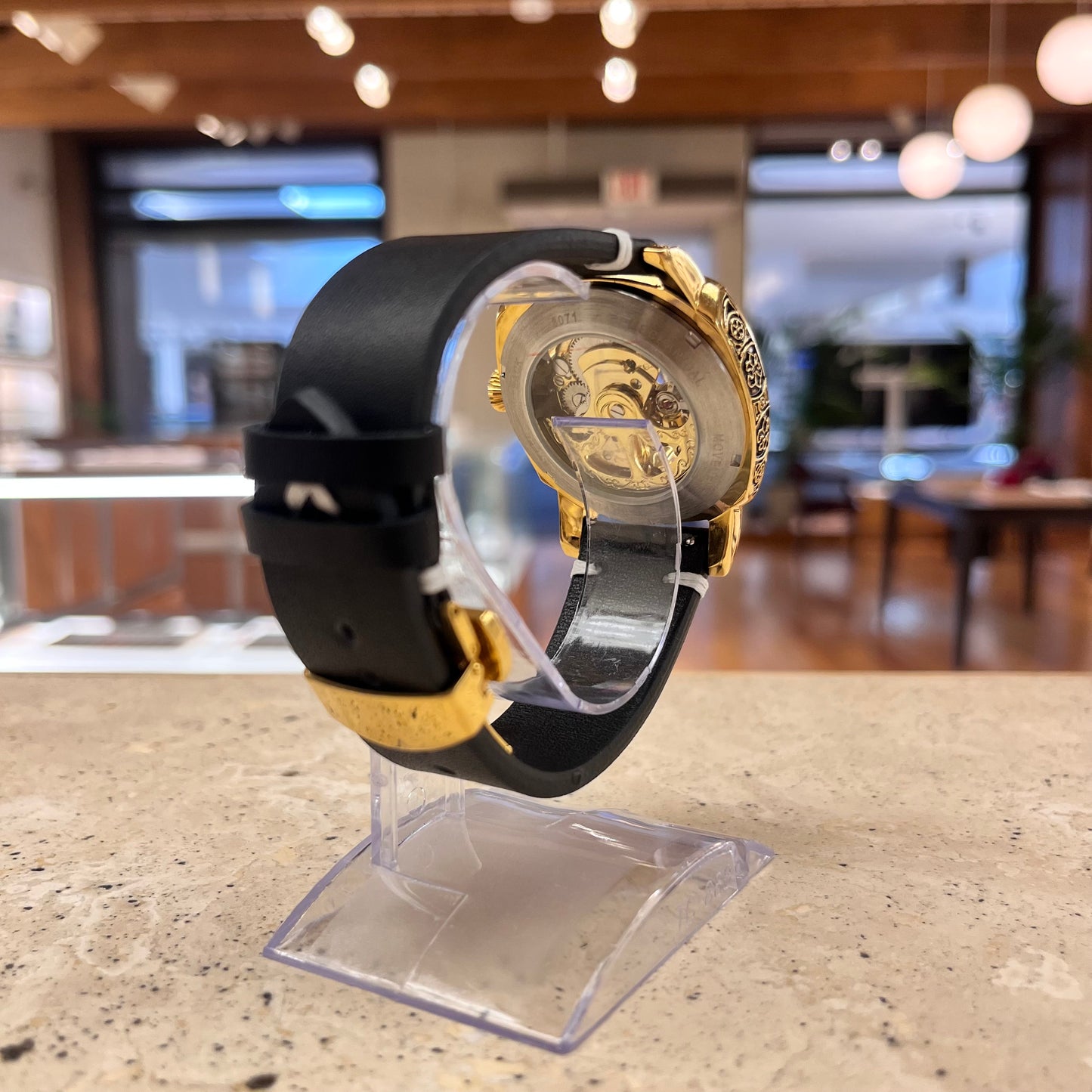 Customized NINE automatic skeleton watch with gold-colored case, luminous display, and black handmade leather band with gold butterfly clasp, shown on a wrist, demonstrating size and style.