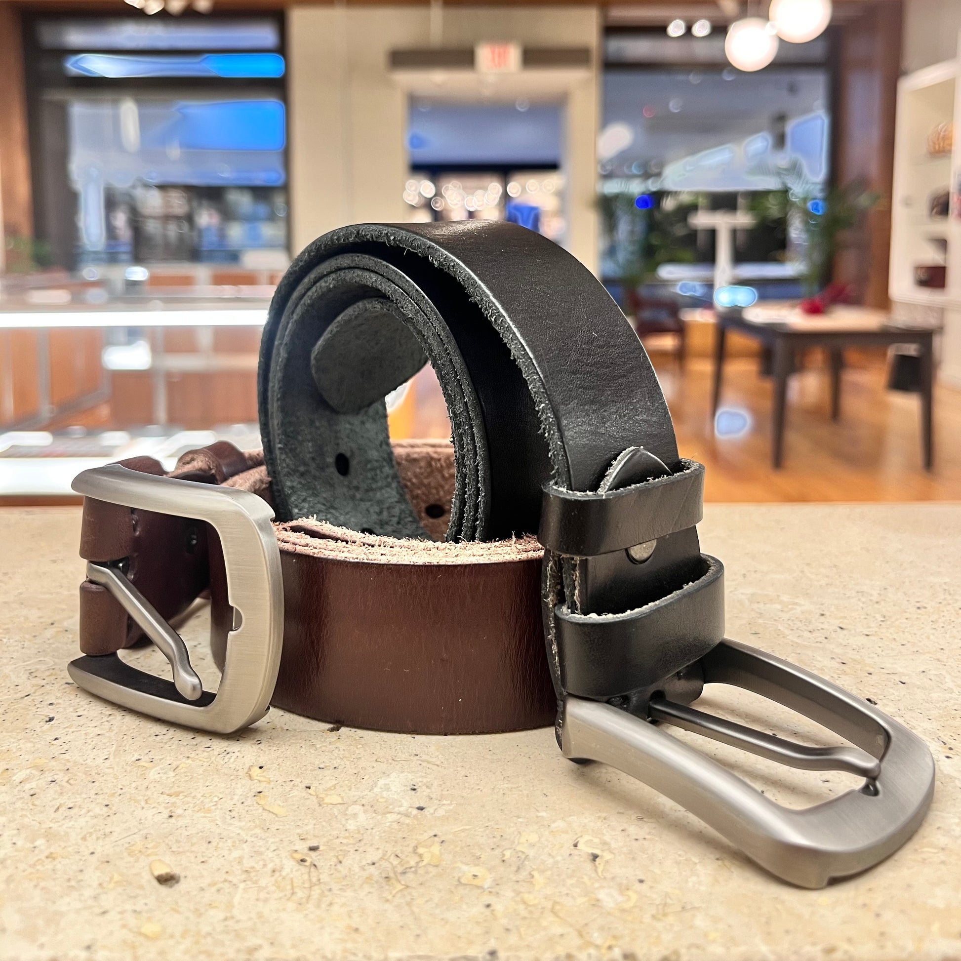 Two leather belts, one black and one brown, showcasing the classic color options available.