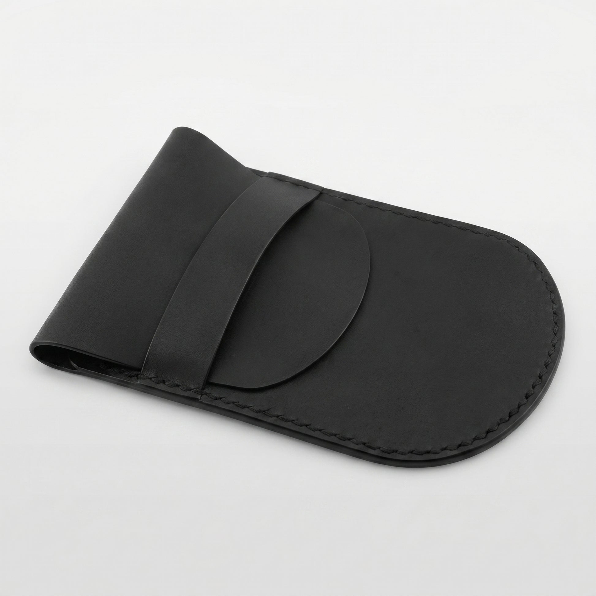 Minimalist black full-grain leather protective case for Apple Magic Mouse featuring hand-stitched edges and a secure leather strap closure on a white background.