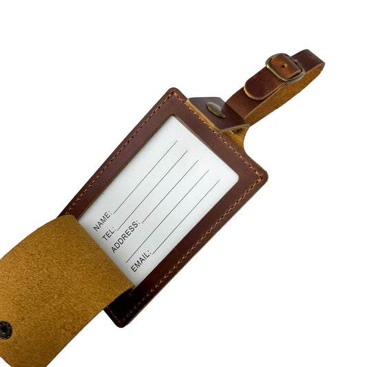 Brown leather luggage tag open to show ID card holder with fields for name, phone number, address, and email, made by Nine Leather & Watch.