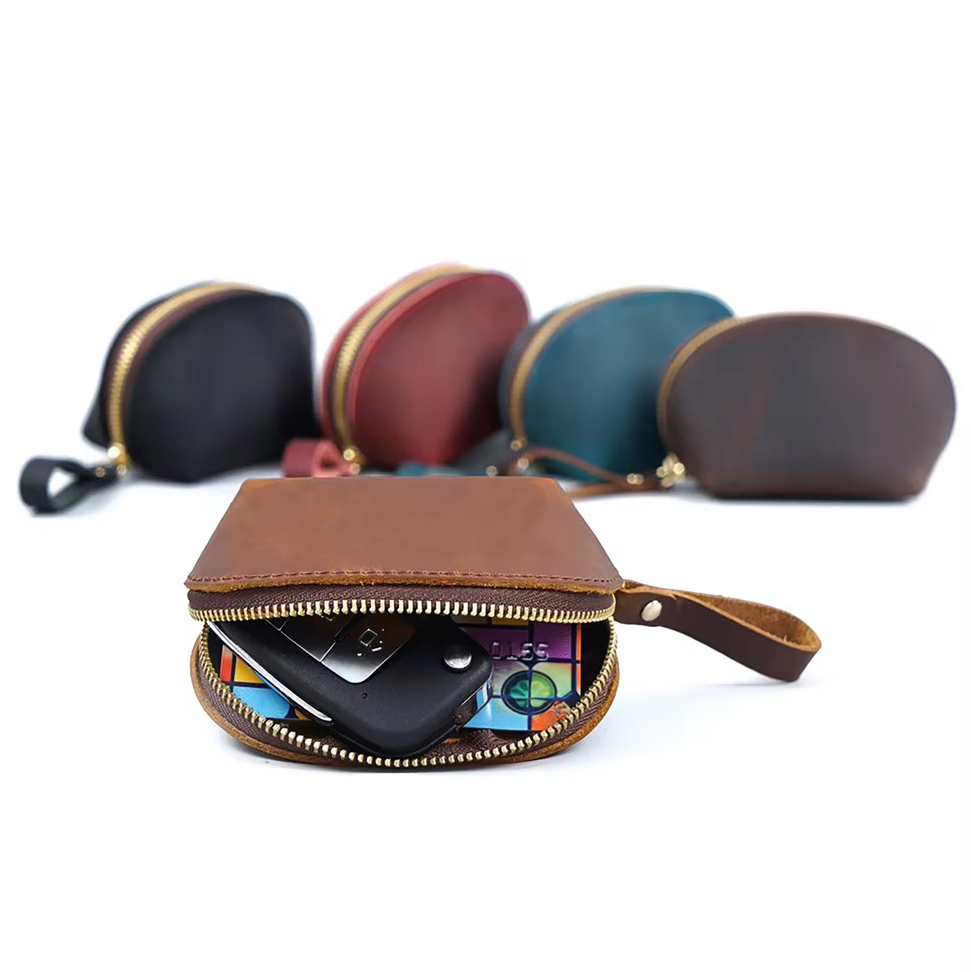 A group of vintage leather coin bags in brown, tan brown, blue, red, and green, with a tan brown bag in the foreground open, showcasing its contents.