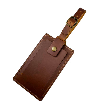Stylish tan brown leather luggage tag with clear ID window, perfect for travel.