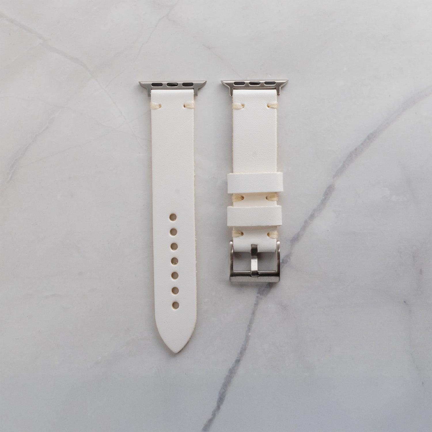 Premium white full-grain leather Apple Watch strap with cream-colored artisan stitching and silver-tone hardware for a refined, luxury look.