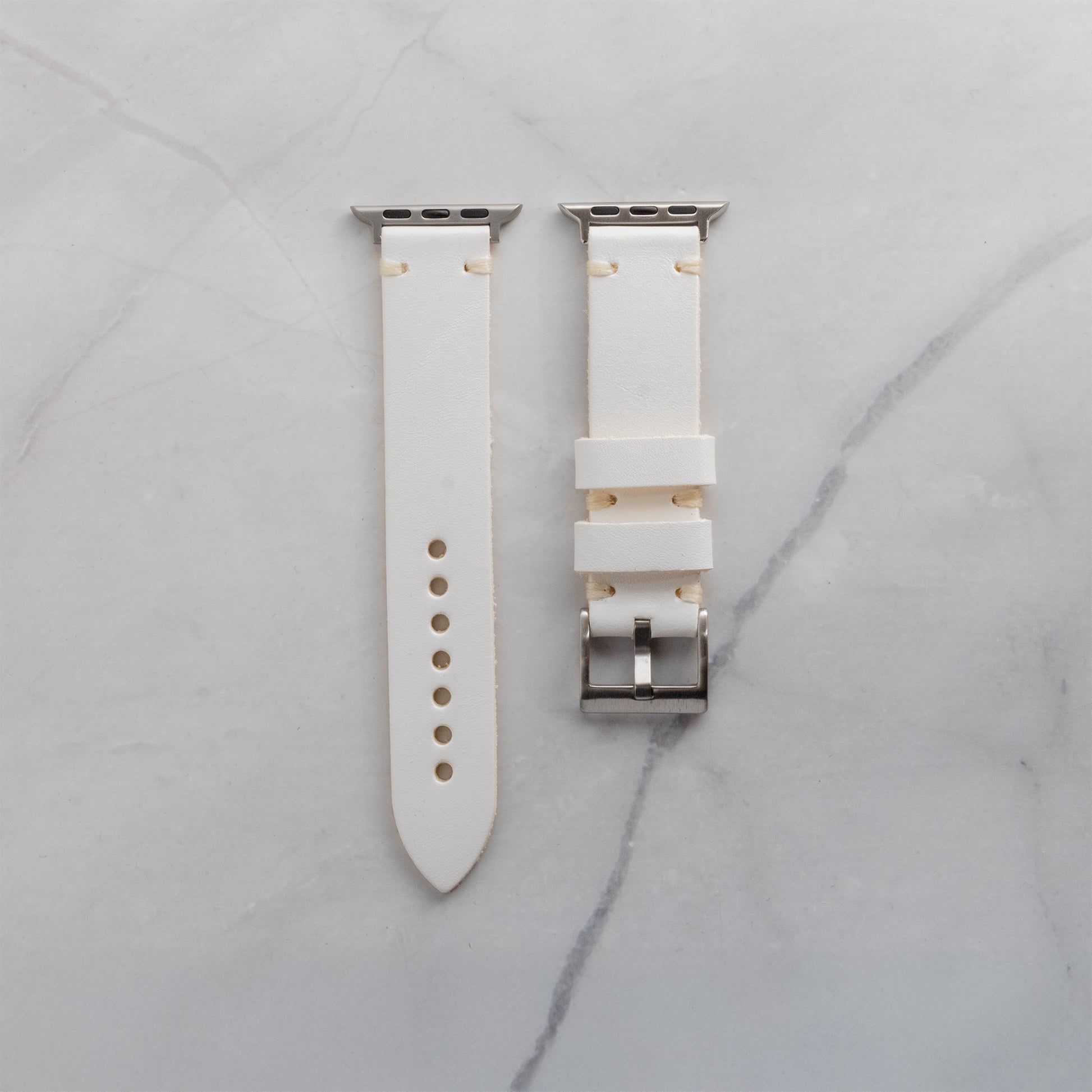 Premium white full-grain leather Apple Watch strap with cream-colored artisan stitching and silver-tone hardware for a refined, luxury look.