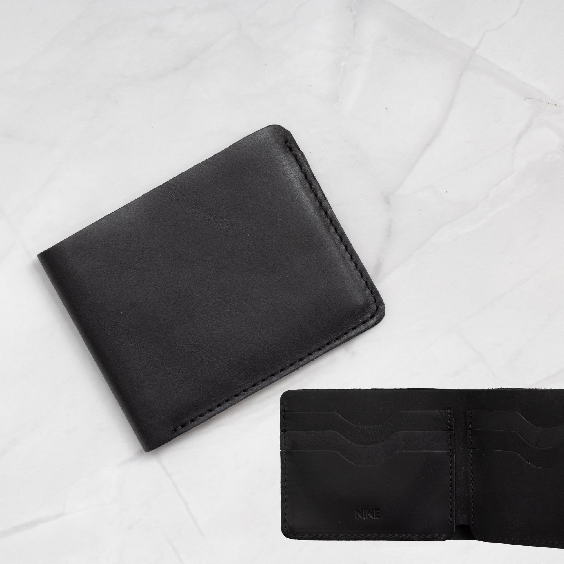 Black Full-Grain Leather Classic Bifold Wallet with a slim profile and 6 card slots.