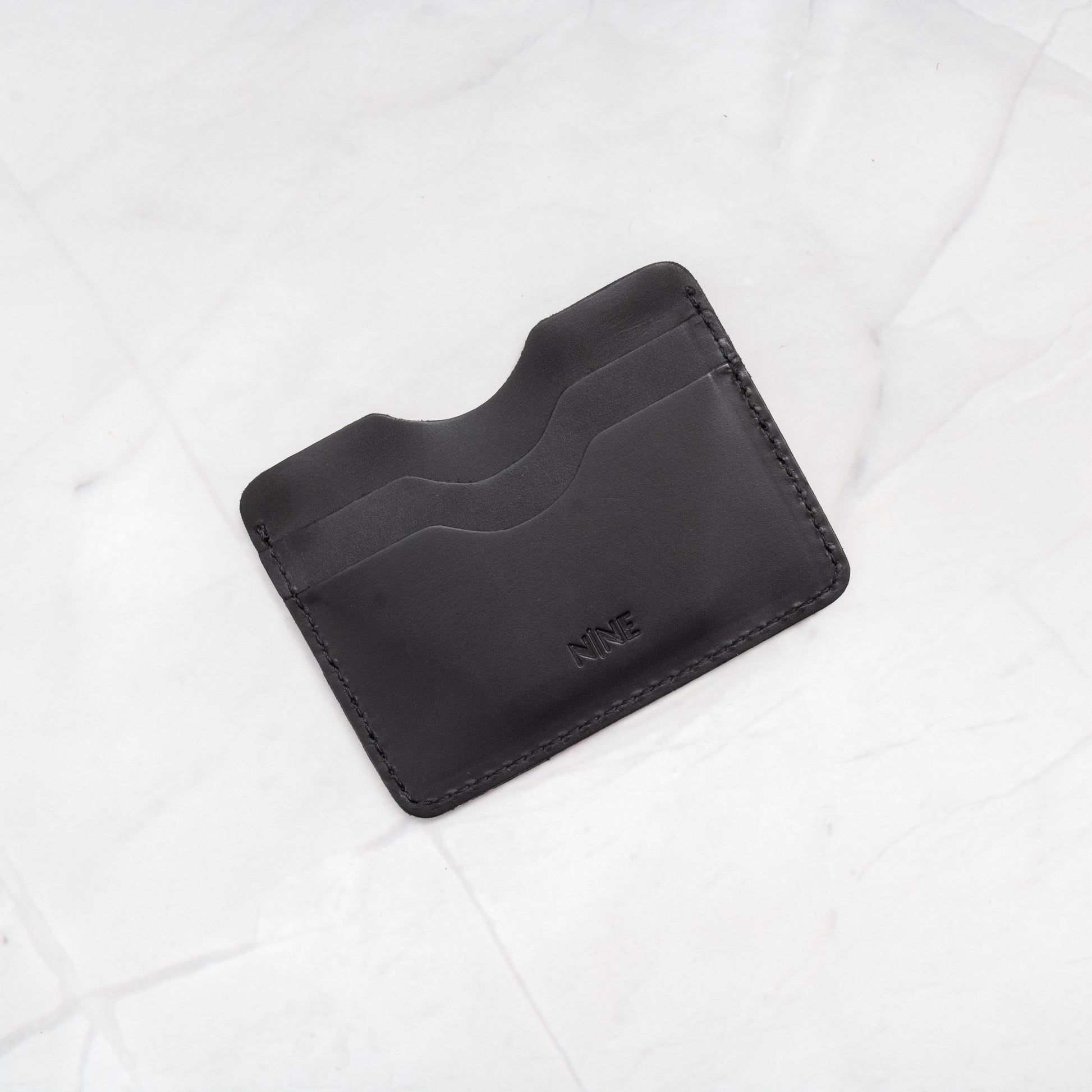 Black Full-Grain Leather Compact Card Wallet, showcasing the 4-slot minimalist design.