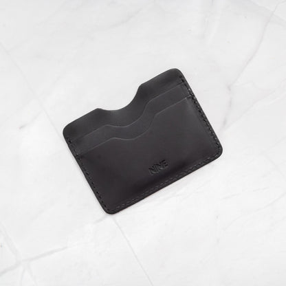 Black Full-Grain Leather Compact Card Wallet, showcasing the 4-slot minimalist design.