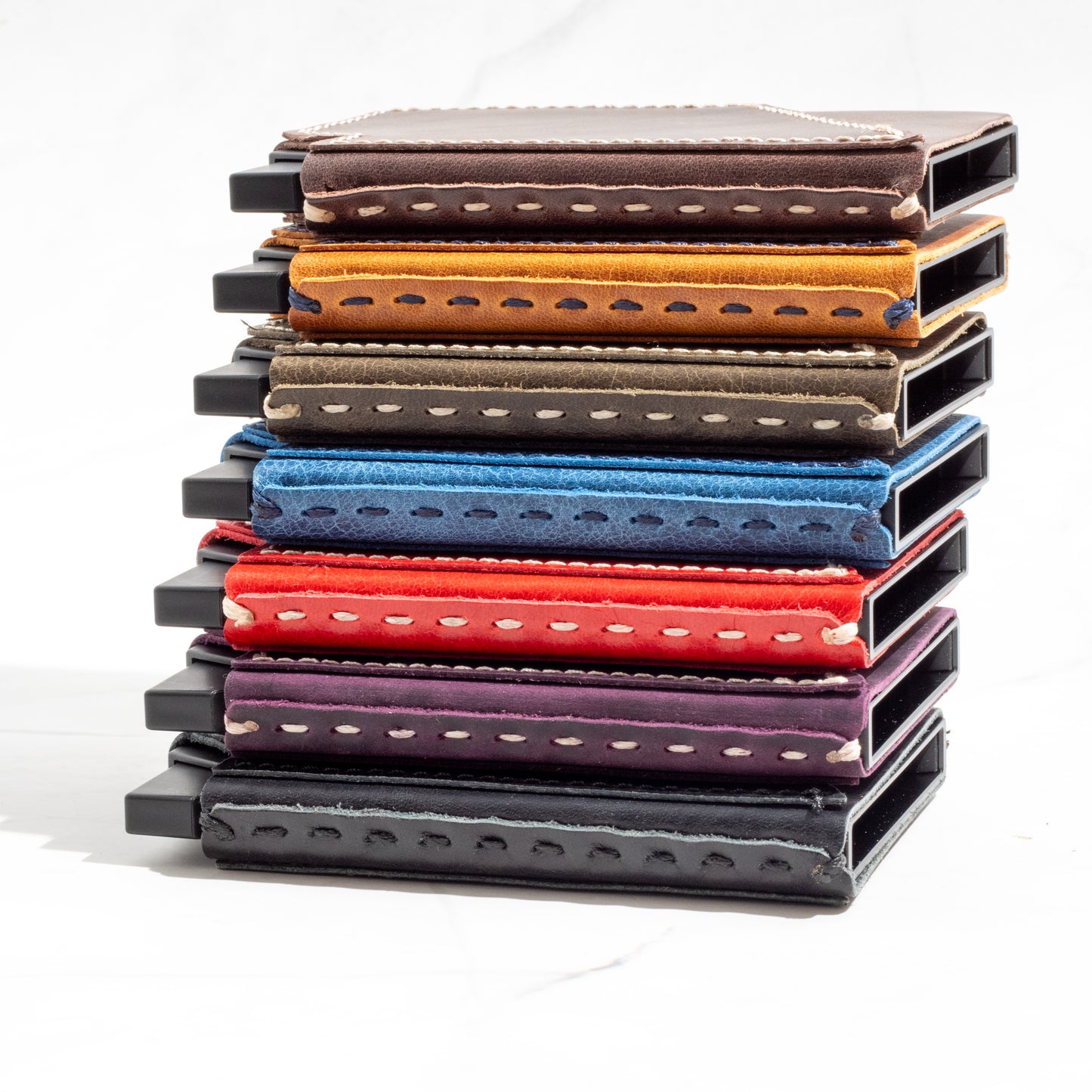 Side-by-side view of a colorful array of NINE Pop-Up Wallets showing contrast stitching and full-grain leather texture