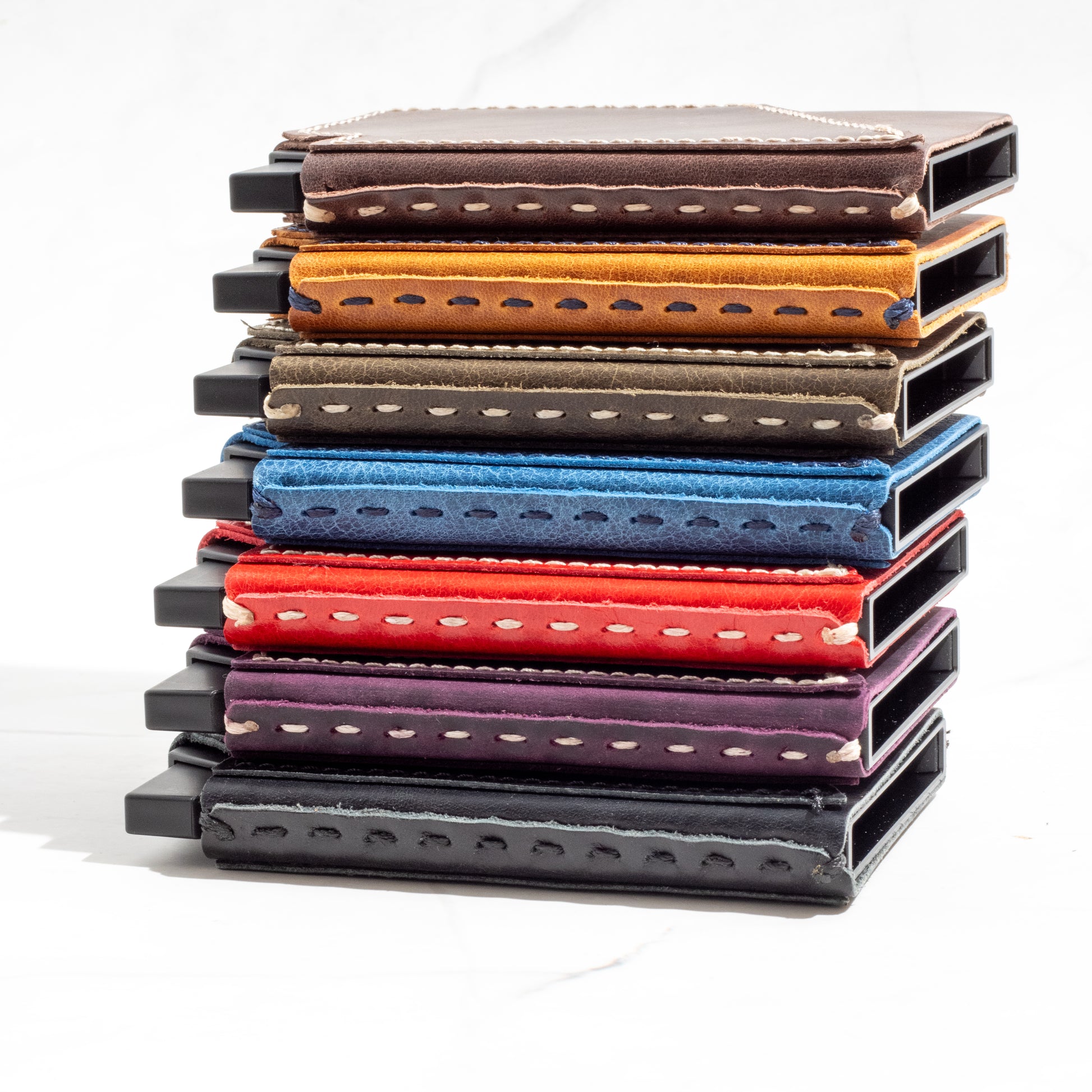 Side-by-side view of a colorful array of NINE Pop-Up Wallets showing contrast stitching and full-grain leather texture