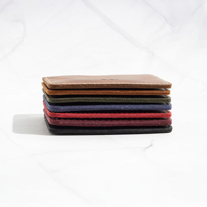 Stack of NINE Compact Card Wallets in various Full-Grain Leather colors, showcasing the ultra-slim profile.