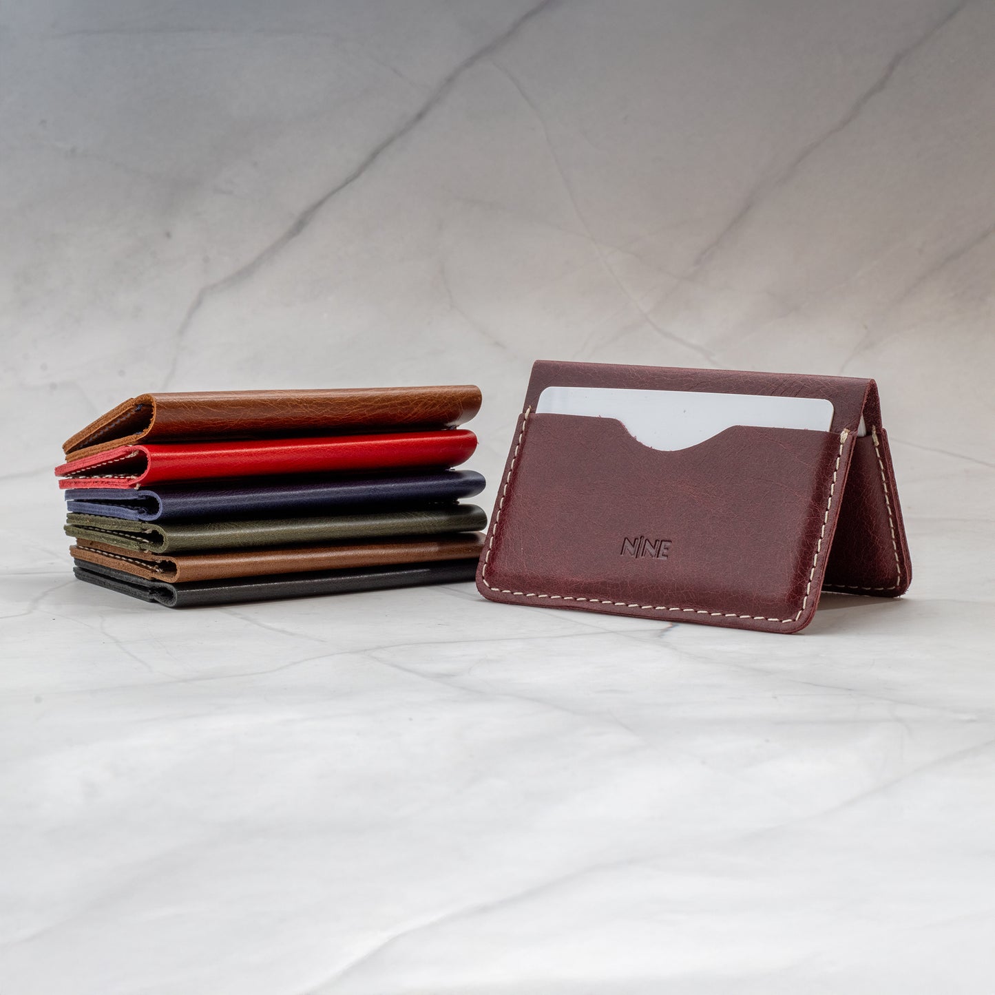 Stack of NINE Minimalist Bifold Leather Wallets showing the slim design and large capacity.
