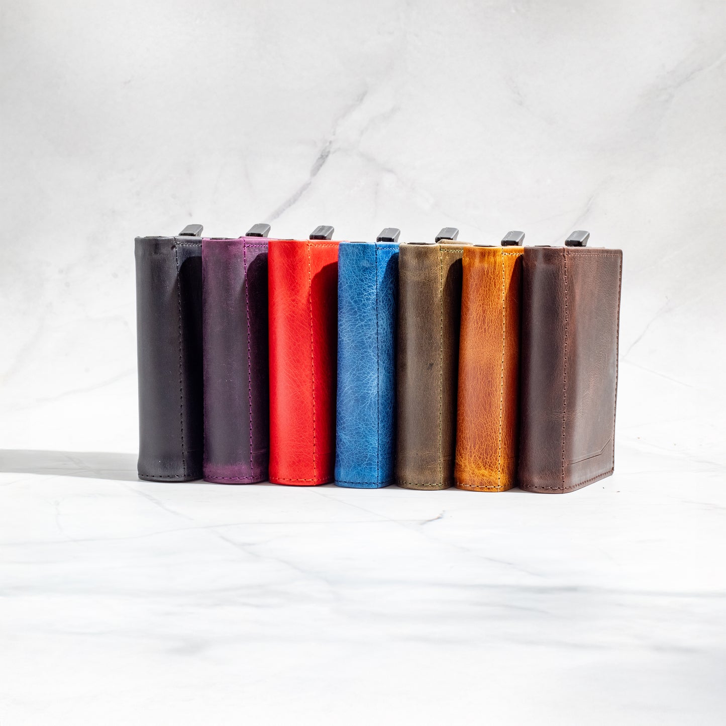 Side-by-side lineup of NINE Pop-Up Trifold Wallets showing the full range of full-grain leather colors.