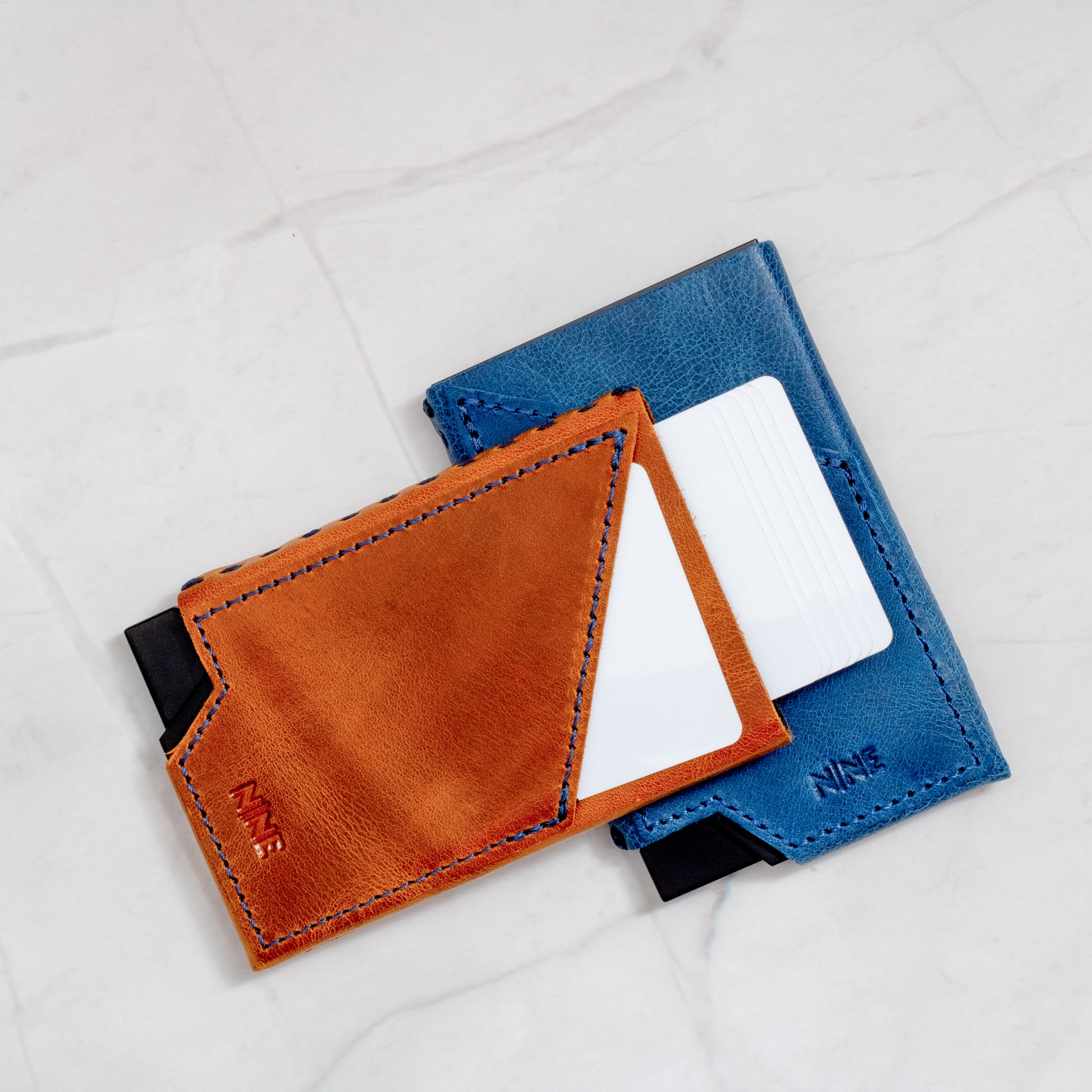 Two NINE Pop-Up Wallets, Tan and Blue, with cards visible, demonstrating the quick-access design