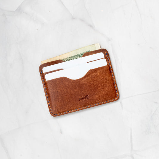 Tan Full-Grain Leather Compact Card Wallet holding essential cards and folded cash in the main slot.