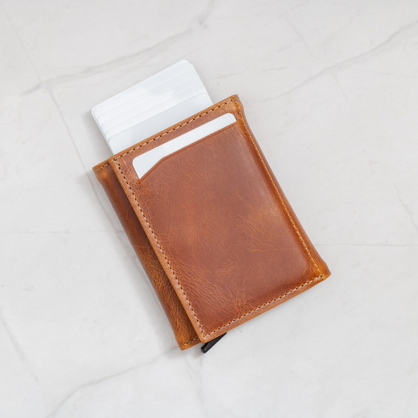Exterior view of the Tan Pop-Up Trifold Wallet with cards fanned out, demonstrating the mechanical quick-access feature.