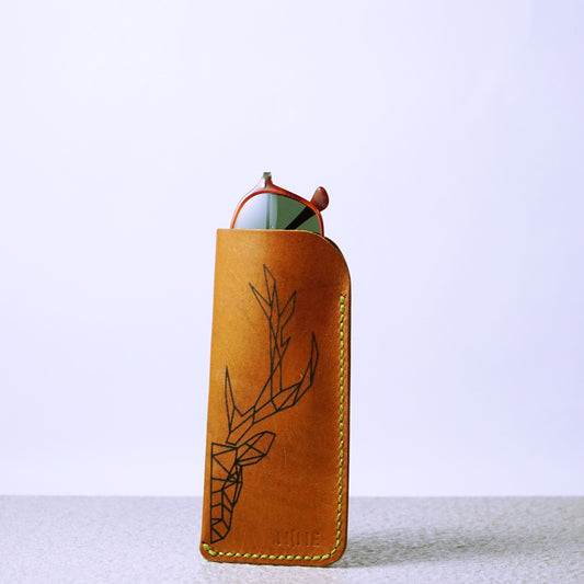 A brown leather sunglasses case with a pair of sunglasses inside, showcasing its slim profile and protective design.
