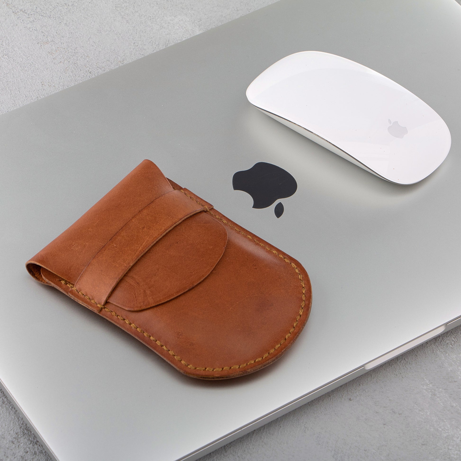 Apple Magic Mouse with the leather case on a MacBook, demonstrating its functionality and sleek appearance.